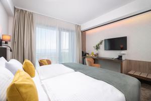 a hotel room with a bed and a television at Montello Hotel in Balatonfüred