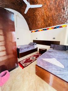 a room with three beds and a ceiling at Dara guest House in Aswan