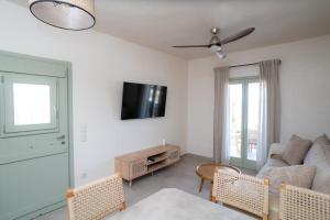 a living room with a couch and a tv at Small Cyclades Houses in Koufonisia