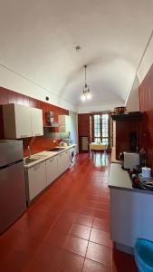 a kitchen with white cabinets and a red tile floor at Cascinotto Stella Silvia in Piossasco +23 photos