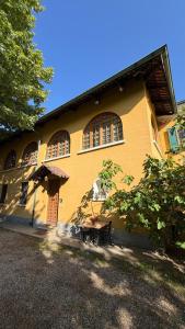 a yellow building with a table in front of it at Cascinotto Stella Silvia in Piossasco