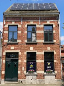 a brick building with solar panels on its windows at De Buitenmuur in Turnhout