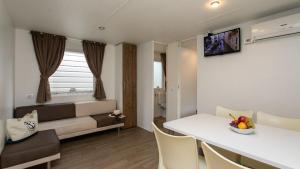 a living room with a couch and a table with a bowl of fruit at Camping Klaus in Cavallino-Treporti