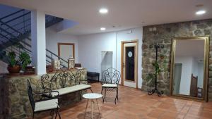 a living room with a bench and chairs and a staircase at Ruralis Las Nogalas in Montánchez