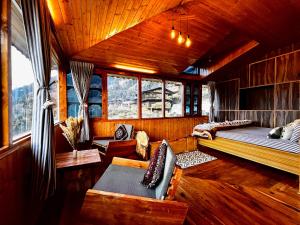 a bedroom with a bed and a couch in a cabin at Nirvana Trueliving in Nagar
