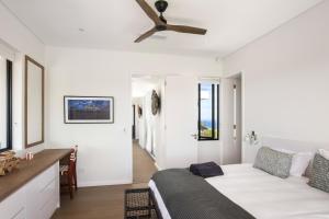 a living room with a couch and a ceiling fan at La Villa at Pezula in Knysna +50 photos