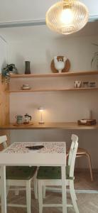 a table and chairs in a kitchen with a light at "Les Chacobins" - appart'étape avec Garage Vélos in La Réole