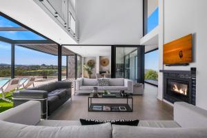 a living room with white furniture and a fireplace at La Villa at Pezula in Knysna