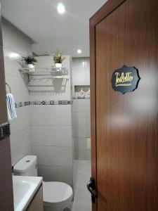 ein Badezimmer mit Toilette und Holztür in der Unterkunft PalmRest in Marrakesch