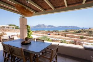 a dining room with a table and chairs and a view of the ocean at Small Cyclades Houses in Koufonisia