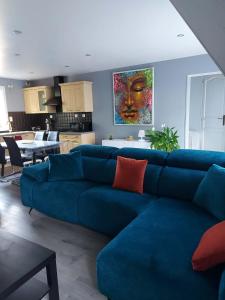 a living room with a blue couch and a kitchen at au pont vieux in Chanac