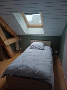 a bed in a room with a window and stairs at au pont vieux in Chanac