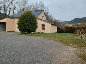 a white house with a tree next to a driveway at au pont vieux in Chanac