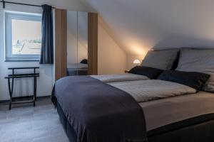 a bedroom with a large bed with a window at Asweiler Landliebe - klimatisierte Premiumfewo mit Balkon und Fernblick in Freisen