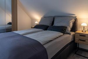 a bedroom with a large bed with two pillows at Asweiler Landliebe - klimatisierte Premiumfewo mit Balkon und Fernblick in Freisen +21 photos