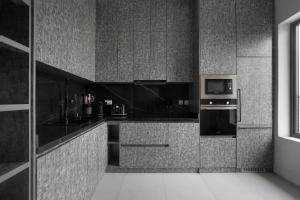 a black and white kitchen with a stove and microwave at 108 Opebi Executive Apartments in Lagos