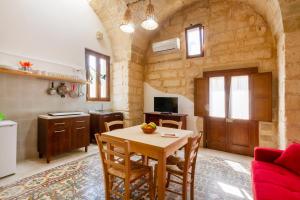 a kitchen and dining room with a table and chairs at GuestHost - La Pizzica Apartment in Cannole