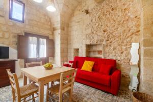 a living room with a red couch and a table at GuestHost - La Pizzica Apartment in Cannole