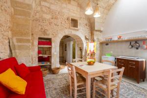 a living room with a red couch and a table at GuestHost - La Pizzica Apartment in Cannole