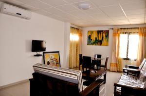 a living room with a table and chairs and a tv at Guest House Lumen in Lomé