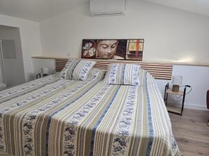 ein Bett mit einer gestreiften Bettdecke in einem Schlafzimmer in der Unterkunft Chicken Fields Good ! in Auch
