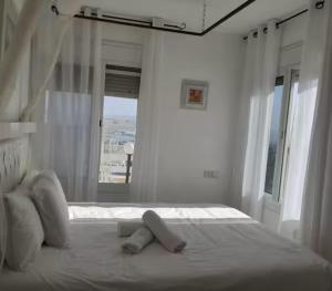 a white bedroom with a bed with two teddy bears on it at אצל דניאל במושבה - 2 צימרים מושלמים עם נוף לכינרת in Kinneret