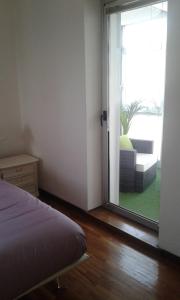 a bedroom with a bed and a sliding glass door at La Finestra Sul Mare in Trieste