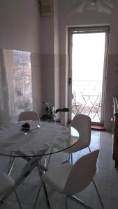 a dining room with a glass table and chairs at La Finestra Sul Mare in Trieste