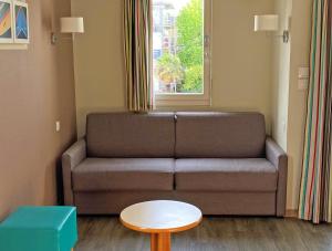 a living room with a couch and a table at Résidence Pierre & Vacances Ty Mat in Saint Malo