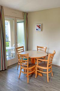 a dining room with a table and chairs and a balcony at Résidence Pierre & Vacances Ty Mat in Saint Malo