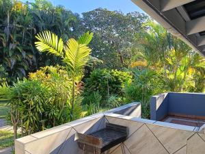 a balcony with a bench and trees in the background at Ocean House in St Lucia
