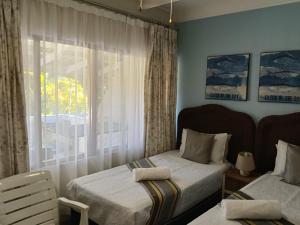 a bedroom with two beds and a window at Ocean House in St Lucia +29 photos