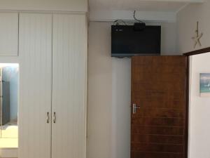 a room with two white cabinets and a television on the wall at Ocean House in St Lucia