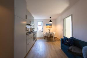 a kitchen and a living room with a couch and a table at FeWo-Ahrenshoop in Prerow