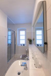 a white bathroom with a sink and a mirror at FeWo-Ahrenshoop in Prerow +11 photos