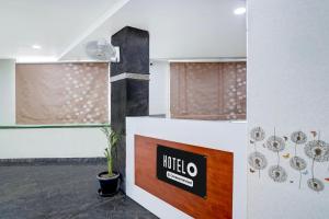 a room with a table with a sign on it at Super Hotel O Magunta Layout Nellore Formerly The Paradise Guest Inn in Nellore +21 photos