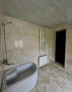a bathroom with a bath tub in a room at Maia's Guest House Gergeti in Kazbegi