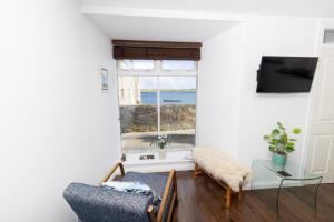 a living room with a window with a view of the ocean at Bains Closs, Shetland Islands in Lerwick +30 photos