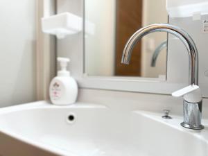 a bathroom with a sink and a mirror at Hotel Suite 24 in Warabi +18 photos
