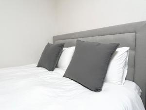a bed with two gray pillows on top of it at Hotel Suite 24 in Warabi