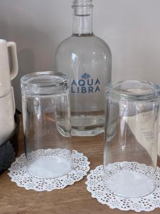 two glasses and a bottle of water on a table at Balreask Bar, Restaurant & Guest Accommodation in Navan