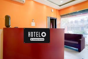 a hotel lobby with a sign on the wall at Super Hotel O Sankaradeva Kalakshetra Formerly HK Residency in Dispur