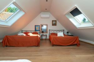 two beds in a attic room with skylights at Stientjeshof "Het Paardenhuisje & Hooihuys " in Sint-Lievens-Houtem