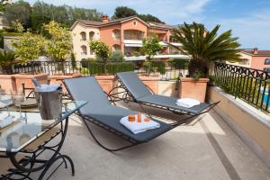 a deck with a chair and table on a balcony at Sunny Panoramic Balcony in Èze