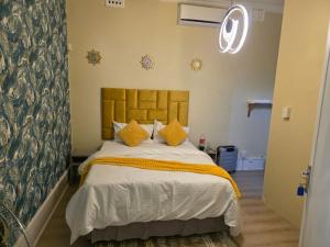 a bedroom with a large bed with yellow pillows at Peaceful Accommodation in Durban