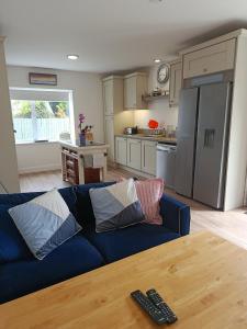 a living room with a blue couch and a kitchen at Countryside bliss in Clonakilty