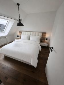 a bedroom with a large white bed and a window at Ruheoase Quickborn in Quickborn