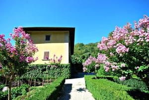 ein Gebäude mit rosa Blumen vor einem Hof in der Unterkunft Villa Salaiole in Castiglione