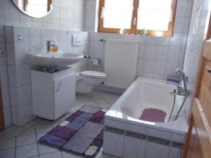 ein Badezimmer mit einem Waschbecken, einer Badewanne und einem WC in der Unterkunft Ferienwohnung Luzia in Eichstegen