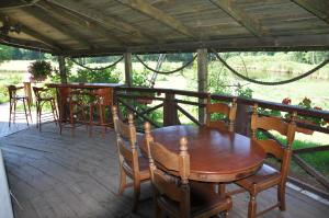 a wooden table and chairs on a patio at Pensjonat Dolina Wierzby in Olsztyn